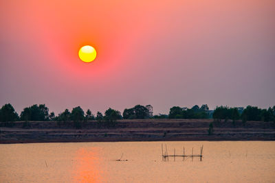 Scenic view of field against orange sky