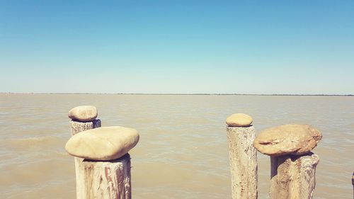 Rocks in sea against clear sky