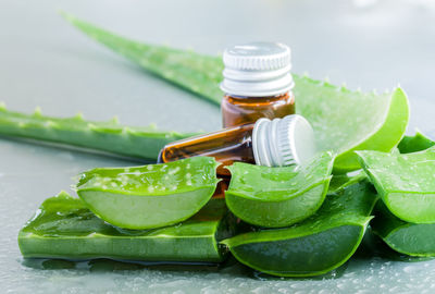 Close-up of essential oil and aloe slices on table