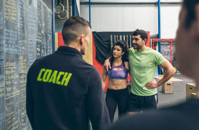 Instructor explaining over blackboard to athletes in gym