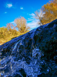 Scenic view of waterfall against sky