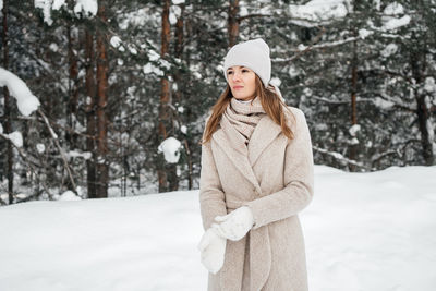 Portrait of a girl in warm clothes in a winter forest