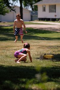 Full length of mother and daughter in yard