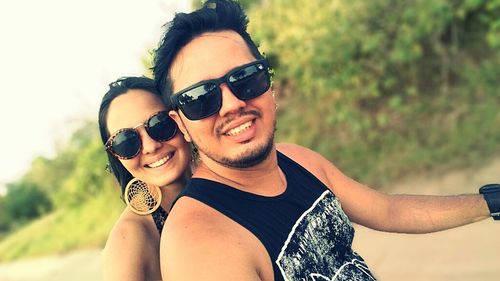 Portrait of a smiling young woman wearing sunglasses