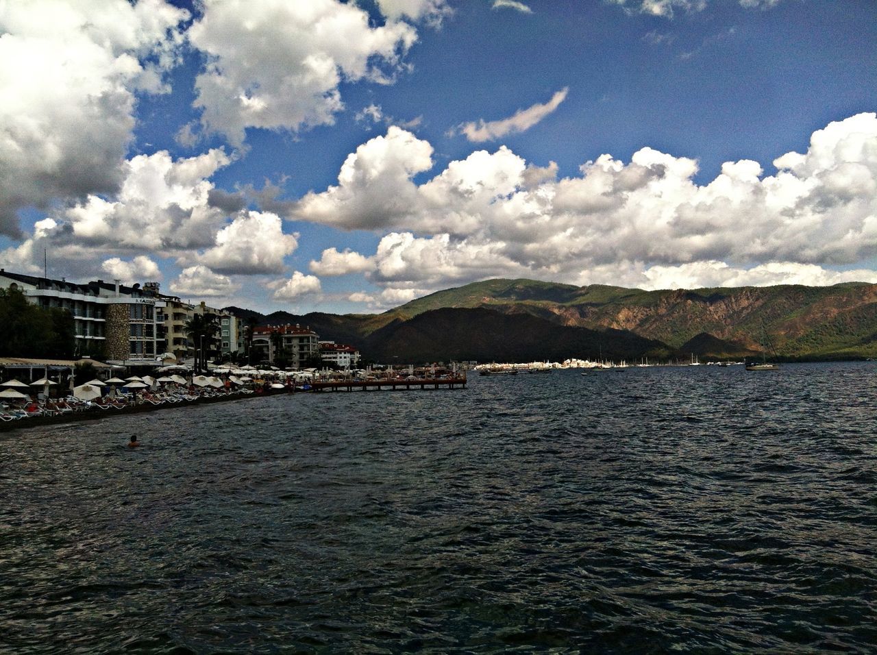 water, sky, architecture, built structure, waterfront, cloud - sky, building exterior, river, cloud, rippled, mountain, cloudy, nature, tranquil scene, sea, scenics, city, tranquility, transportation, beauty in nature