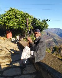 Portrait of man holding umbrella on sunny day