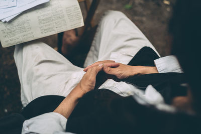 Midsection of man holding paper