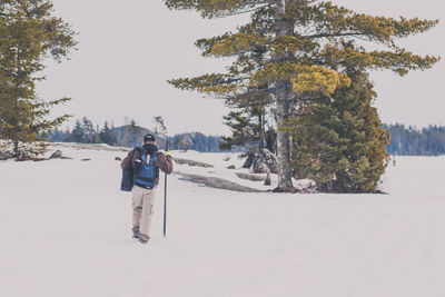 People on snow covered landscape against clear sky