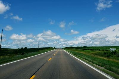 Road passing through land against sky