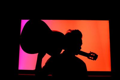 Silhouette man playing guitar