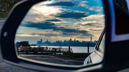 Reflection of sky on side-view mirror of car