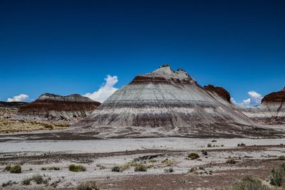 View of arid landscape against clear blue sky