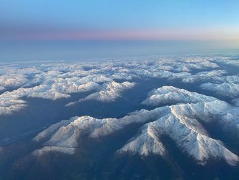 Aerial view of snowcapped landscape against sky