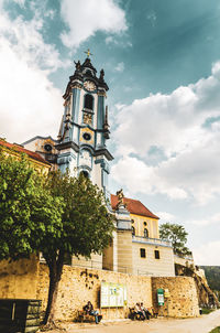 Low angle view of church by building against sky