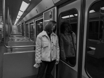 Rear view of woman standing in train