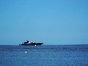 Scenic view of sailboat in sea against clear sky