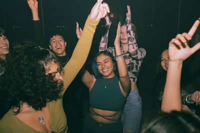 Cheerful young friends dancing and enjoying together at nightclub