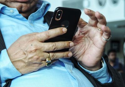 Midsection of man using mobile phone