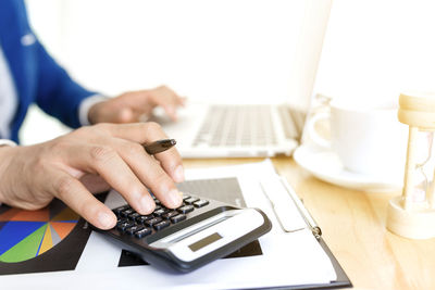 Midsection of man using laptop on table