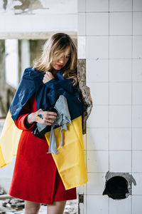 Portrait of woman standing near tiled wall