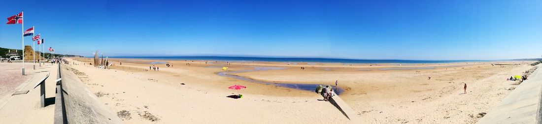 Scenic view of beach against clear blue sky