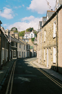 Road amidst buildings against sky