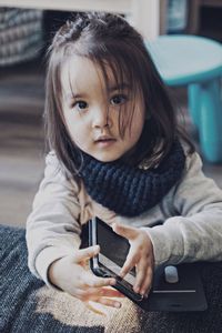 Portrait of cute girl holding mobile phone