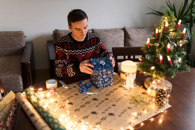 Young man packs christmas presents for friends and family