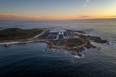 Amazing drone aerial landscape view of a sea fishing farm on land at sunset in galiza, spain