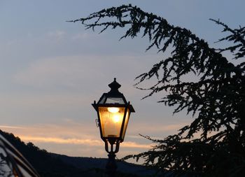 Illuminated street light against sky