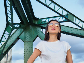 Woman wearing sunglasses while standing against sky