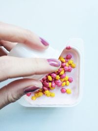 Close-up of cropped hand holding food over white background