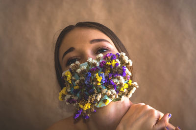 Close-up of woman with flowers on mouth