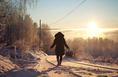 Woman standing on snow covered landscape