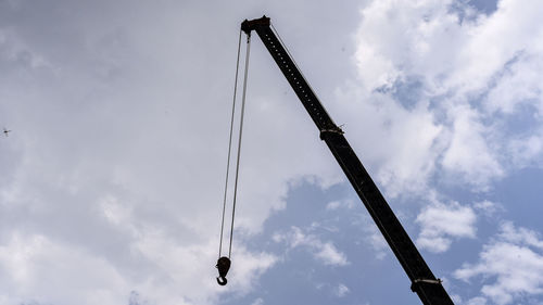 Low angle view of crane against sky