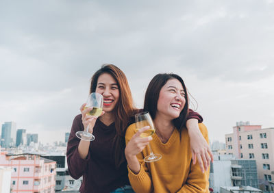 Friends laughing while drinking wine