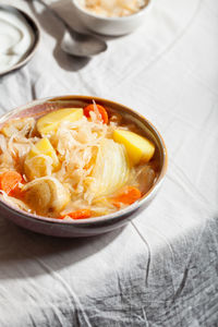 High angle view of vegetarian sauerkraut soup shchi with veggies in bowl. comfort healthy food