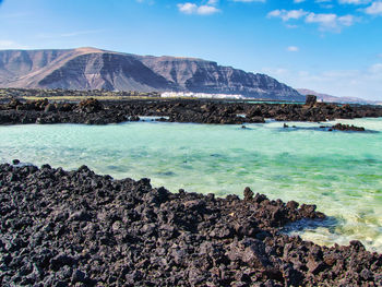 Scenic view of sea and mountains against sky