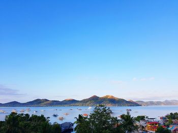 Scenic view of sea and mountains against blue sky