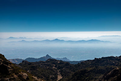 Scenic view of mountains against clear blue sky