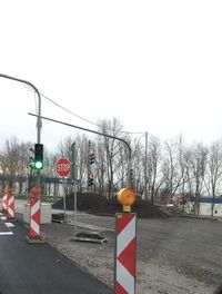 Road sign by street against clear sky