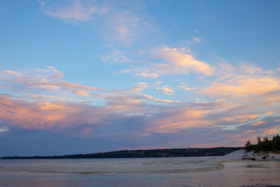 Scenic view of beach against sky at sunset