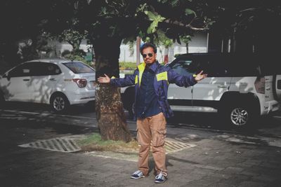 Full length portrait of man standing on street in city