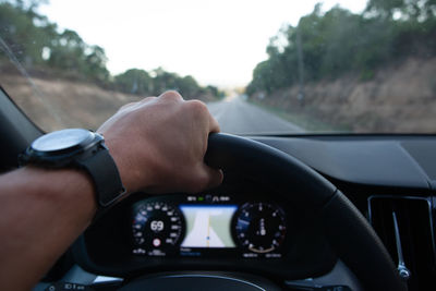 Cropped hand of man driving car