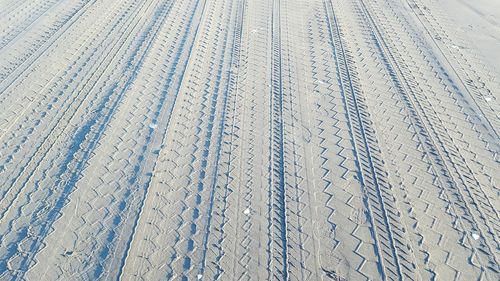 High angle view of tire tracks on sand