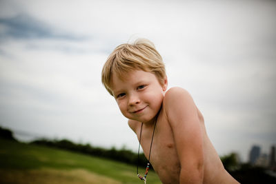 Shirtless six year old boy smiling for camera in coronado