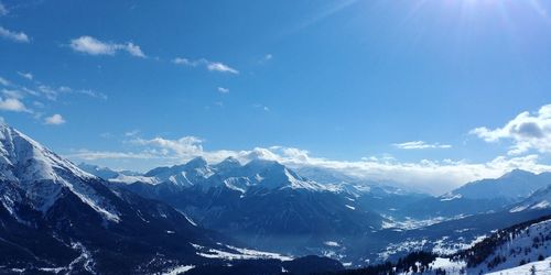 Scenic view of snowcapped mountains against blue sky