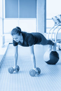 Full length of woman exercising in gym