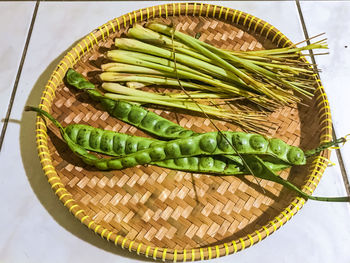 A traditional vegetable petai and lemon grass placed on a bamboo basket.