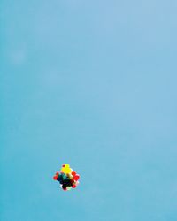 Low angle view of balloons flying against clear blue sky